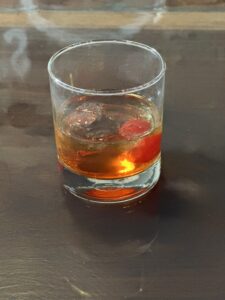 Vintage-inspired cocktail with a twist of nostalgia - Old Fashioned cocktail in a classic glass with a muddled sugar cube, aromatic bitters, and a twist of orange peel, garnished with a cherry. A timeless libation that exudes sophistication and elegance